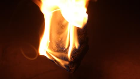 Close-up-of-a-fireball-burning-in-slow-motion-as-the-flames-drip-down-in-the-darkness
