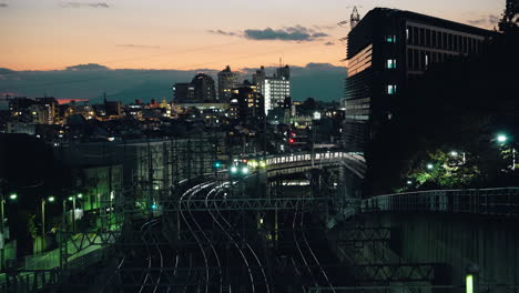 Zug-Bewegt-Sich-Langsam-Auf-Der-Eisenbahn-Mit-Obenliegendem-Stahldachstuhl-In-Der-Abenddämmerung-In-Der-Innenstadt-Von-Tokio