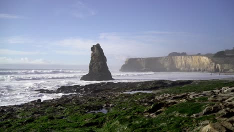 Big-Rock-Formation-in-the-Ocean-with-Cliffs-in-the-Background