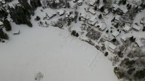 Aerial-rising-shot-of-quiet-snow-covered-northern-Canadian-community---town-along-side-a-railway-system
