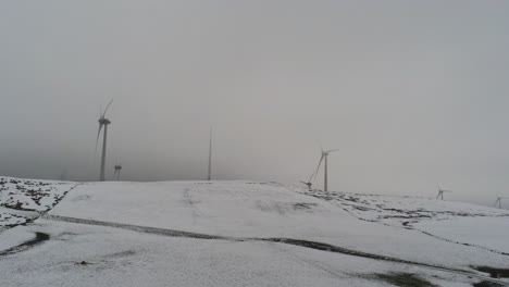 Campo-De-Montaña-De-Invierno-Turbinas-De-Viento-En-Las-Tierras-Altas-Rurales-Vista-Aérea-Valle-Nevado-Frío-Ladera-Empujar-Hacia-Adentro