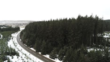 Schneebedeckte-Geschwungene-Winterwaldstraße-Antenne-Nach-Vorne-Blick-Nach-Waldbaumlandschaft