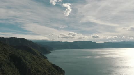 Drone-aerial-view,-flying-high-on-beautiful-lake-Atitlan,-Guatemala,-surrounded-by-mountains