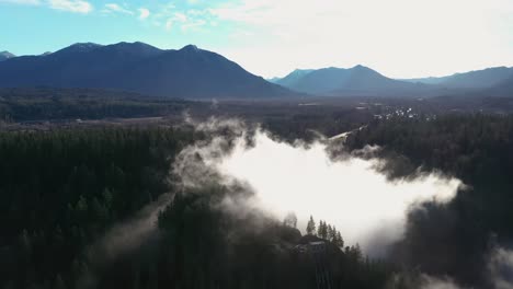 Scenic-Aerial-view-of-Snoqualmie-Waterfall-during-beautiful-summer-day-and-epic-fog-surrounding-the-forest-trees