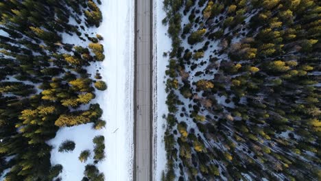 High-Angle-Aerial-View-of-Empty-Road-in-Winter-Mountain-Landscape,-Top-Down-Ascending-Drone-Shot