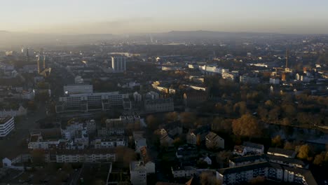 Toma-De-Drones-Del-Paisaje-Urbano-De-Kassel-En-Una-Hermosa-Luz-Solar-Suave-Y-Cubierta-De-Niebla