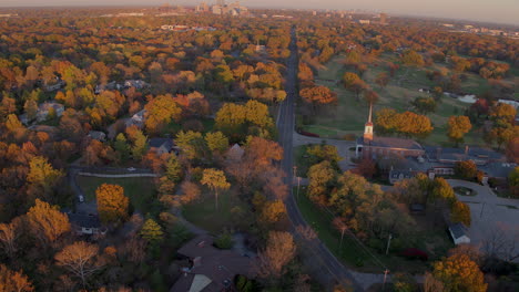 Aerial-of-charming-Ladue-landscape-in-the-Fall-at-peak-color-with-Clayton-Rd-and-a-small-church-with-a-tilt-up-to-reveal-city-of-Clayton-skyline-on-the-horizon-on-a-beautiful-Fall-day