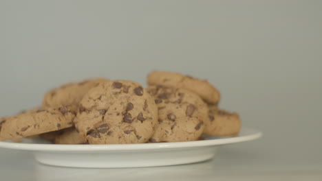 Pile-of-chocolate-chip-cookies-on-a-white-plate---close-dolly-right