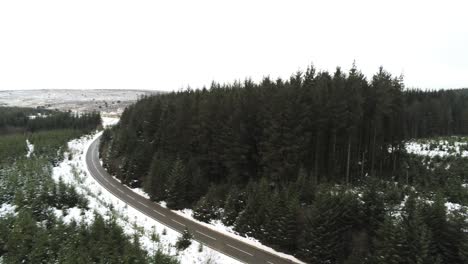 Schneebedeckte-Geschwungene-Winterwaldstraße-Luftrückzugsansicht-Nach-Waldbaumlandschaft