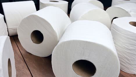 Panning-shot-of-toilet-paper-rolls-on-wood-surface