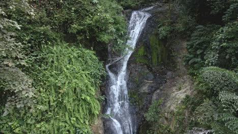 Ascending-drone-medium-shot-waterfall-hidden-in-tropical-rain-forest-jungle