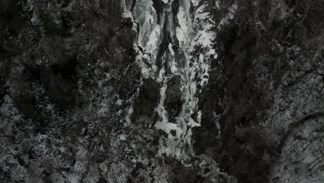 Magnificent-View-Of-Water-Flowing-In-Frozen-Waterfall-In-Valle-Bras-Du-Nord-Canada---aerial-shot