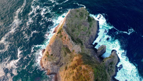 Cinematic-drone-shot-tilting-downwards-to-a-large-rock-on-the-coastline-at-Kyushu-Japan