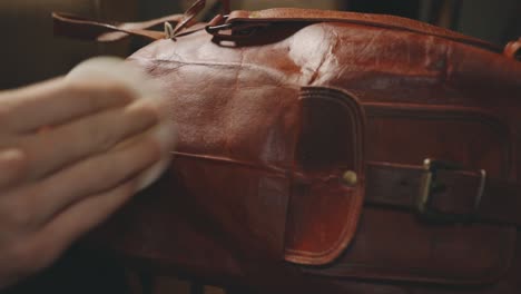 Hand-Polishing-Brown-Leather-Bag-With-Bronze-Latch---close-up
