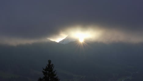 Sonnenstern-Scheint-Im-Morgengrauen-Zwischen-Einer-Berglücke-In-Den-Alpen-Durch-Die-Wolken