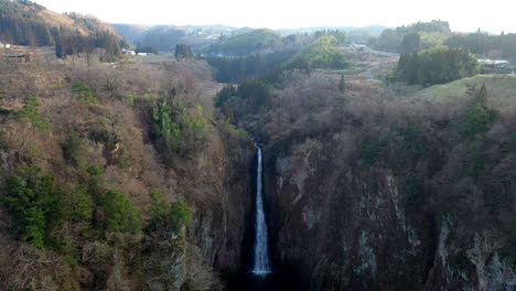 Aufschlussreiche-Drohnenaufnahme-Des-Wasserfalls-An-Der-Hängebrücke-Kokonoe-Yume-Otsurihasi