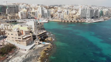 Panning,-aerial-4k-drone-footage-revealing-the-cityscape-of-the-densely-populated-Mediterranean-island-town-of-Sliema,-Malta