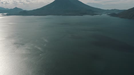 Drone-aerial-revealing-shot-of-the-blue-water-of-Lake-Atitlan-and-San-Pedro-Volcano-in-Guatemala