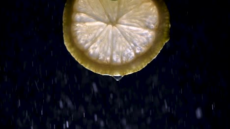 A-fresh-lemon-slice-isolated-on-black-with-mist-at-200-fps-slow-motion