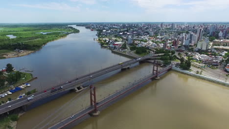 Static-Aerial-View-of-Traffic-on-Bridges-Above-Santa-Fe-River,-Argentina,-Waterfront-and-Cityscape-on-Sunny-Summer-Day,-Drone-Shot