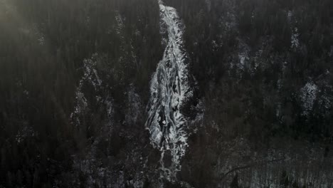 Weiße-Kaskade,-Die-Im-Winter-Von-Waldhügeln-Im-Vallee-Bras-du-Nord-In-Saint-Raymond,-Kanada,-Herabfließt