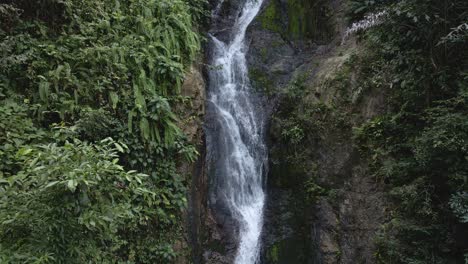 Tilt-down-shot-of-a-beautiful-waterfall-hidden-in-the-tropical-rainforest-jungle-in-Thailand