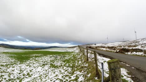 Snowy-rural-winter-weather-over-valley-countryside-aerial-agricultural-farmland-landscape-timelapse