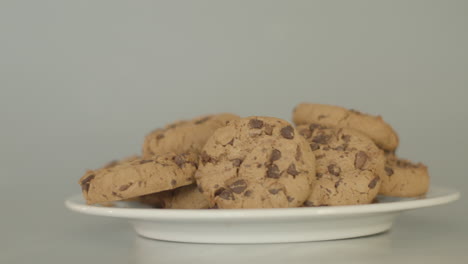 Pile-of-chocolate-chip-cookies-on-a-white-plate---dolly-left