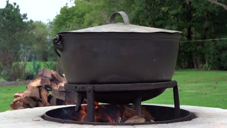 An-old-fashioned-iron-kettle-over-the-fire-of-an-outdoor-campfire