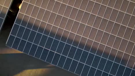Top-down-view-above-renewable-energy-solar-panels-rising-upwards-aerial-view-pull-back