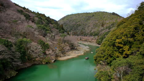 Schöne-Drohnenaufnahme-Eines-Bootes-Auf-Einem-Fluss-In-Kyoto-Japan