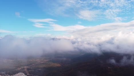 Wolken-Und-Nebel,-Die-Tief-über-Den-Bergen-Fliegen,-Drohnenaufnahme