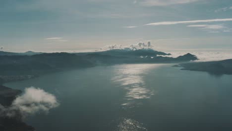 Drone-aerial-overview-of-lake-Atitlan,-high-over-the-clouds-in-Guatemala