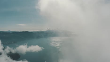 Drone-aerial-flying-high-through-clouds-revealing-lake-Atitlan-in-Guatemala