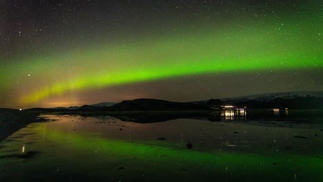 Static-Timelapse-Of-Aurora-Borealis-By-The-Lake-With-Vehicles-On-The-Road-In-Iceland-At-Night---wide-shot