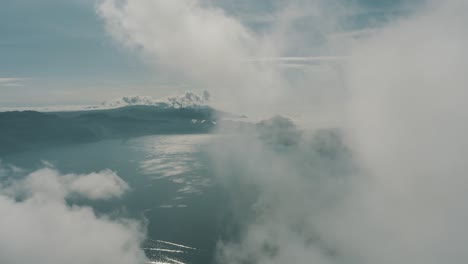 Drone-Aéreo-Volando-Alto-A-Través-De-Las-Nubes-Revelando-El-Hermoso-Lago-Azul-Atitlan-En-Guatemala