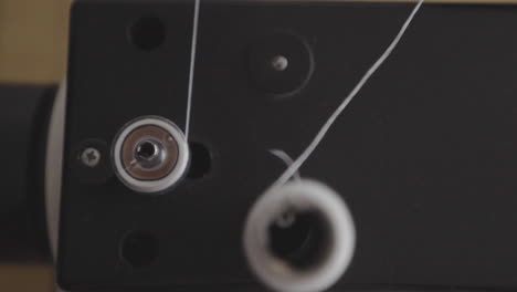 Thread-material-sewing-machine-wheels-spinning-closeup