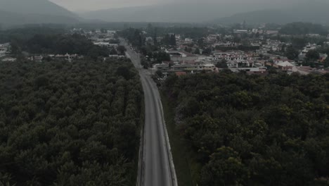 Drone-aerial-view-of-an-empty-highway-next-to-the-forest-during-lockdown