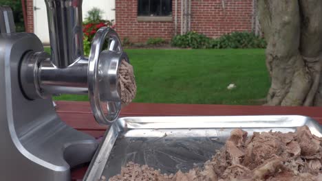 Grinding-meat-in-a-mincing-machine-in-the-outdoors