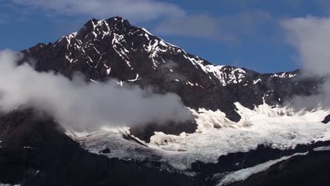 Kleine-Niedrige-Wolken-Um-Den-Schneebedeckten-Berg-Und-Den-Gletscher-In-Der-Glacier-Bay,-Alaska