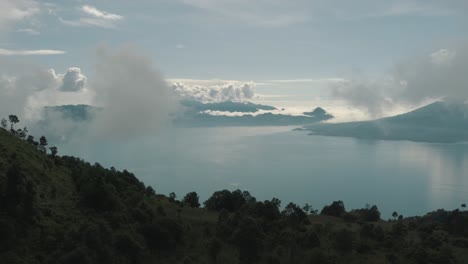 Drone-aerial-view-flying-over-mountains-revealing-beautiful-blue-lake-Atitlan,-Guatemala