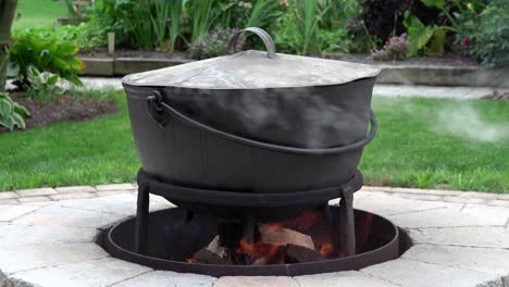 A-fire-burning-in-an-outdoor-fireplace-and-heating-an-old-iron-kettle