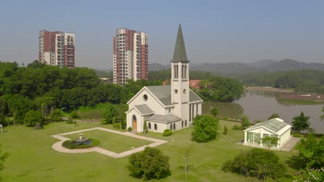 Catholic-style-church-building-without-a-cross-surrounded-with-green-grass-fields-on-a-bright-clear-day