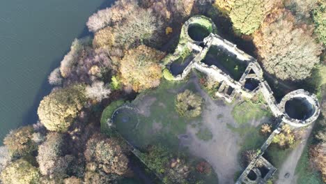 Derelict-Liverpool-castle-replica-ruins-in-Autumn-Rivington-woodland-nature-Landmark-aerial-pull-up-rising-view