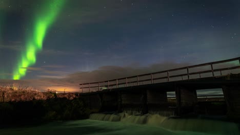 Wondrous-Timelapse-Of-Northern-Lights-By-The-Bridge-Over-A-Flowing-River-In-Iceland---static-shot