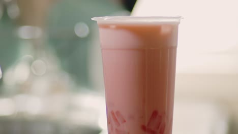 Refreshing-Fruity-Flavor-Bubble-Tea-On-Top-Of-Table-Against-Blurry-Background