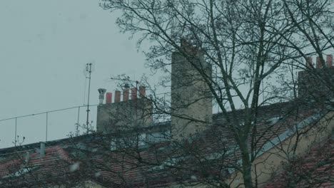 snow-falls-in-slow-motion-in-europe-with-old-chimney-in-the-background