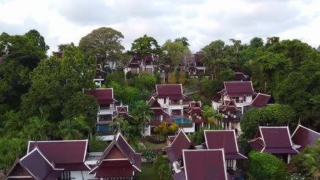 Aerial-footage-of-Asian-Style-rooms-of-a-hotel-with-pools-amongst-a-Jungle-forest-in-Rayong,-Thailand