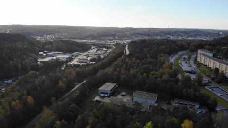 Drone-takeoff-from-scenic-woodland-area-showing-apartments,-Gothenburg
