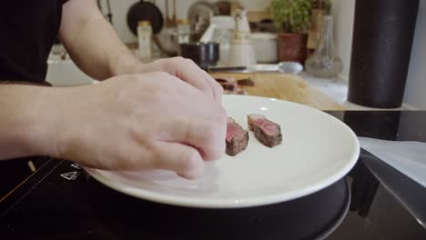 Lay-out-pieces-of-steak-onto-a-white-plate
